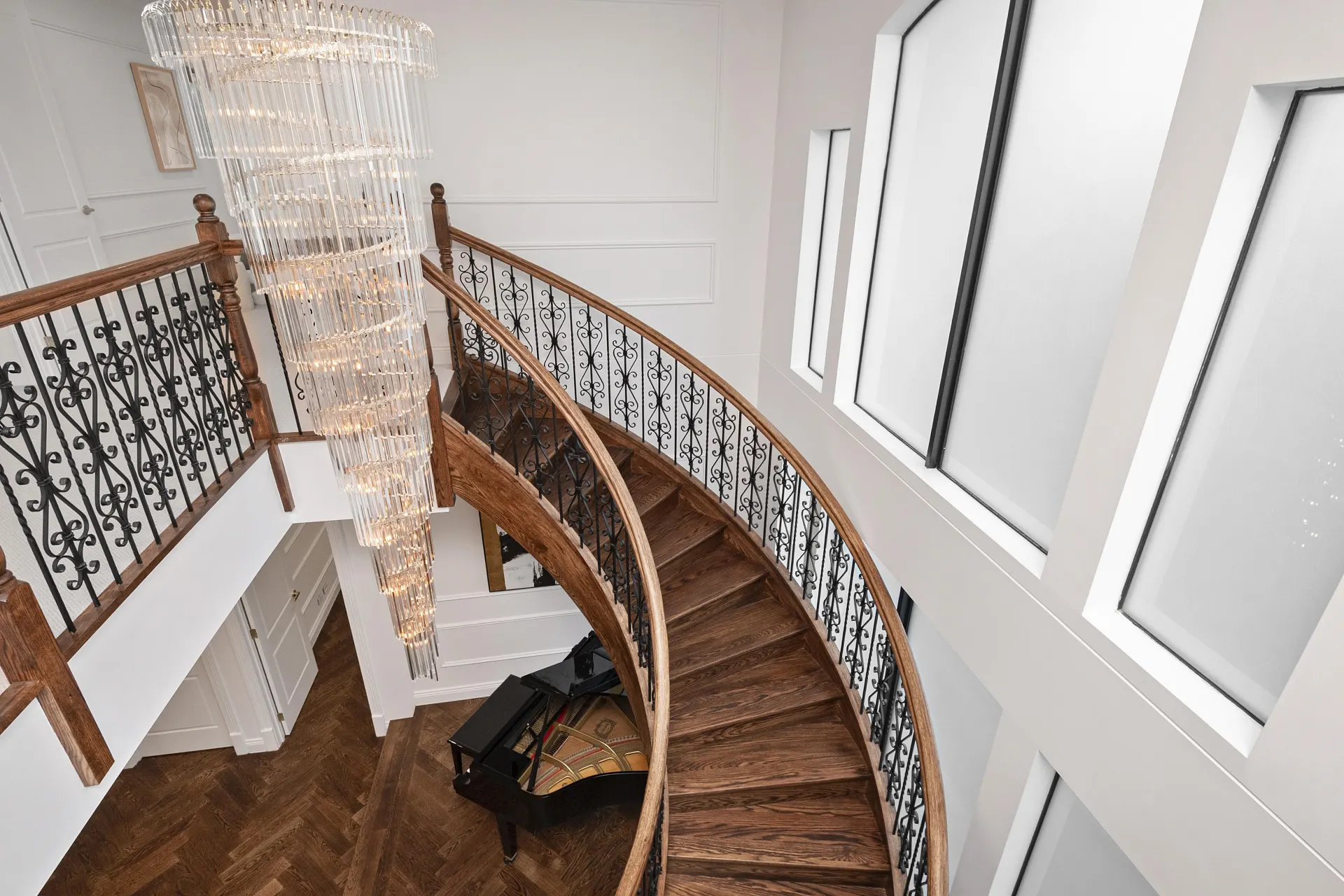 Curved staircase with solid timber treads above the engineered oak herringbone entry